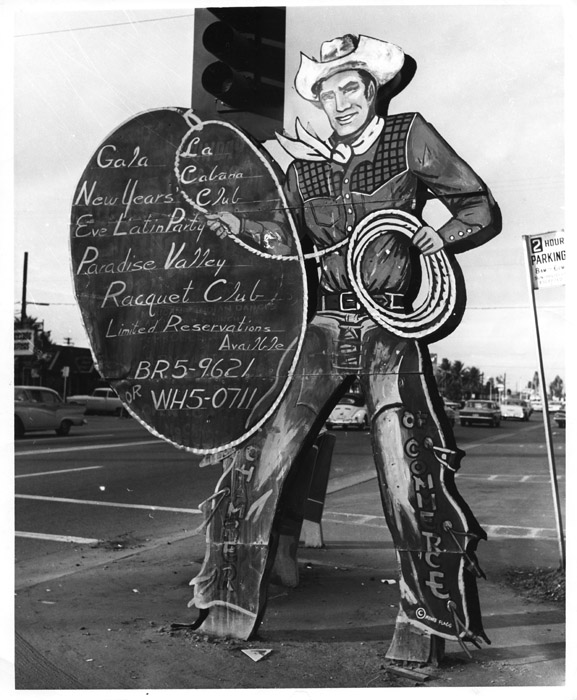 Cowboy Chuck has greeted visitors to Old Town for many years painted cowboy sign with a lasso in black and white