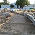 Construction of a pathway leading to City Hall with workers and construction materials on site.