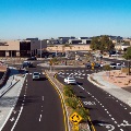 Aerial view of a multi-lane roundabout with cars and buildings in the background.